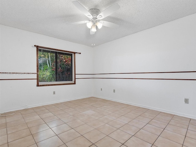 unfurnished room with ceiling fan, light tile patterned floors, and a textured ceiling