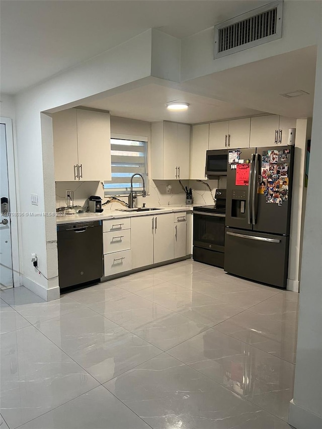 kitchen featuring white cabinetry, sink, and black appliances