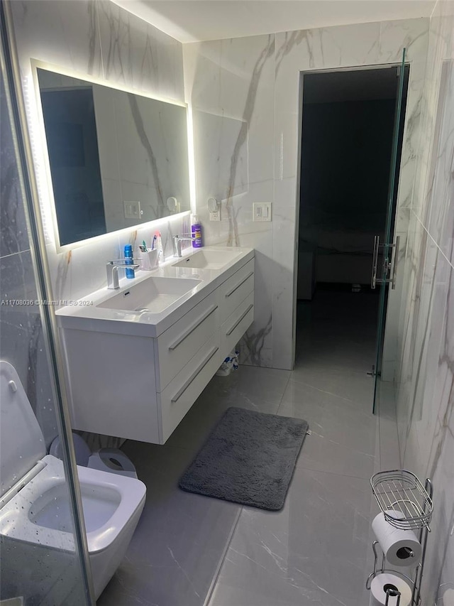 bathroom with vanity, toilet, and tile walls