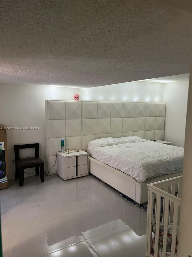 tiled bedroom featuring a textured ceiling