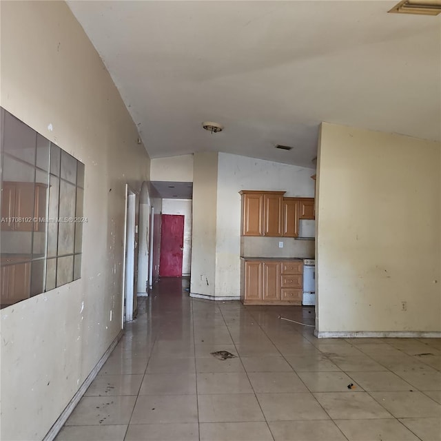 interior space with light tile patterned floors and vaulted ceiling