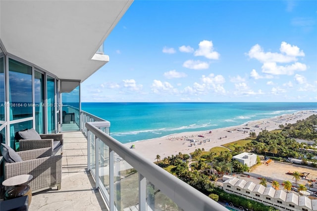 balcony featuring a view of the beach and a water view