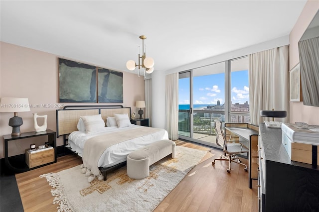 bedroom with a chandelier, access to outside, light wood finished floors, and floor to ceiling windows