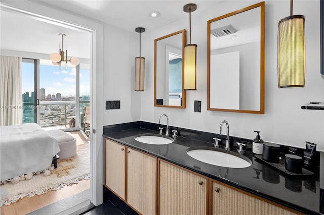 ensuite bathroom featuring a view of city, ensuite bath, a sink, and visible vents