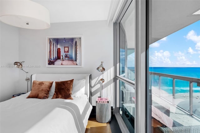 bedroom with a water view and wood finished floors