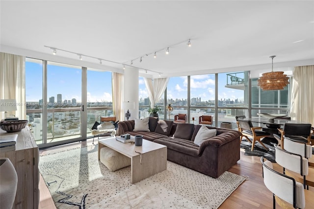 living room featuring a water view, expansive windows, a city view, and wood finished floors