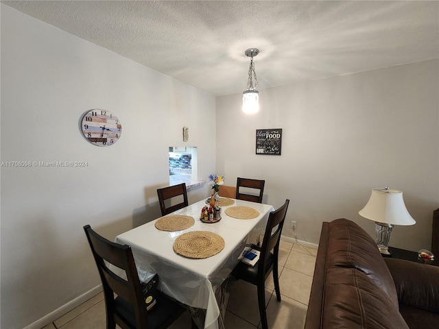 tiled dining room with a textured ceiling