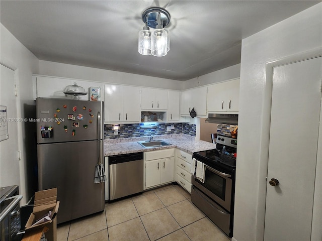 kitchen featuring sink, light tile patterned floors, decorative backsplash, white cabinets, and appliances with stainless steel finishes