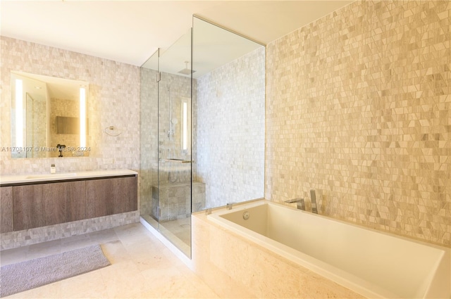 bathroom with tile patterned flooring, vanity, separate shower and tub, and tile walls