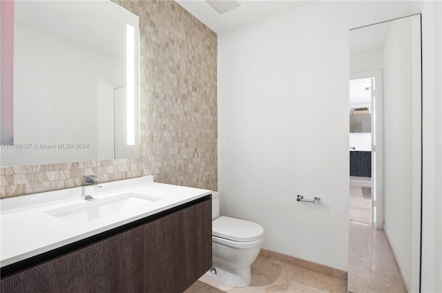 bathroom with tile patterned floors, vanity, toilet, and tile walls