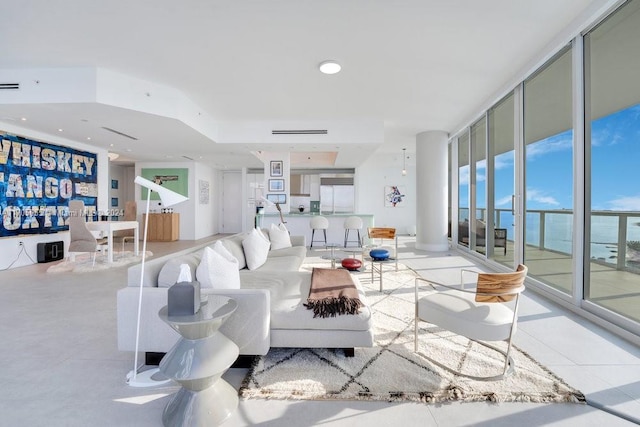 living room featuring a water view and a wall of windows