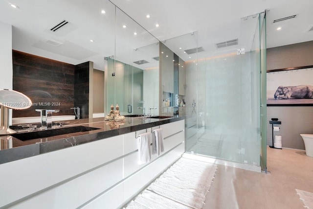 bathroom featuring wooden walls, vanity, concrete floors, and walk in shower