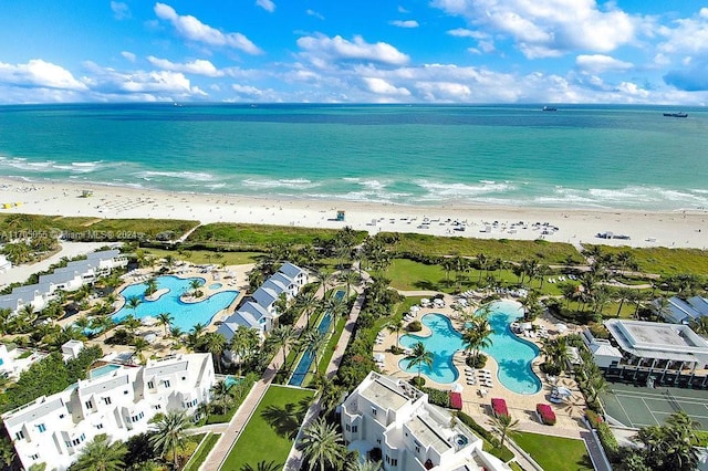 birds eye view of property with a water view and a beach view