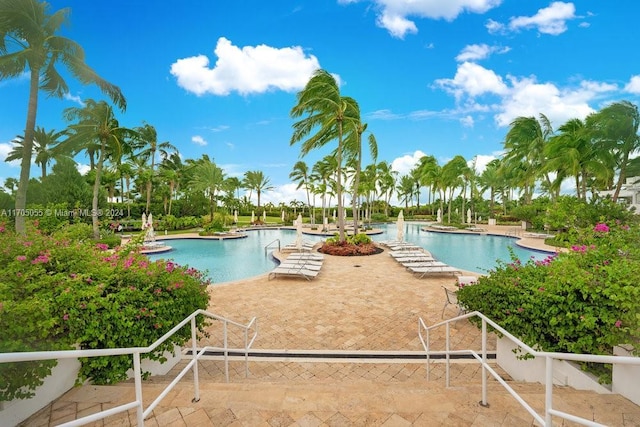 view of swimming pool featuring a water view and a patio