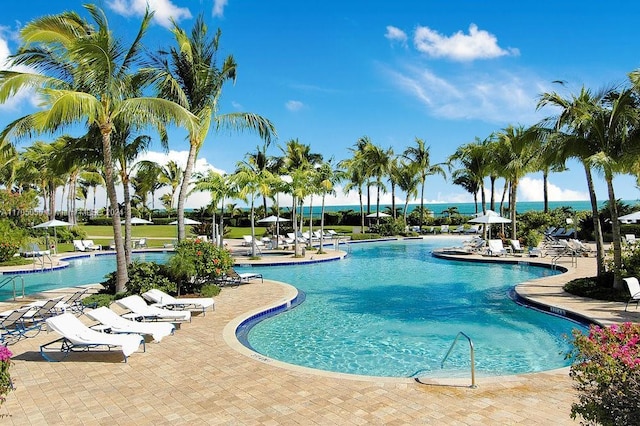 view of swimming pool with a water view and a patio