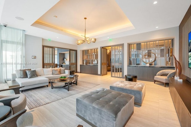 living room with a raised ceiling and a chandelier