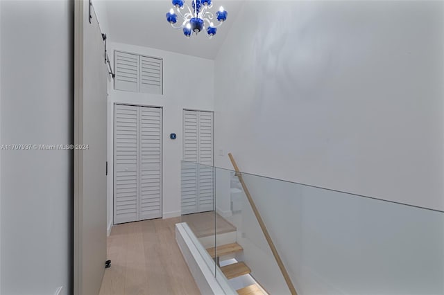 staircase featuring hardwood / wood-style flooring and a chandelier