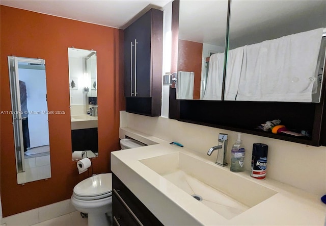 bathroom featuring tile patterned floors, vanity, and toilet