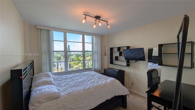 bedroom with light tile patterned floors and track lighting