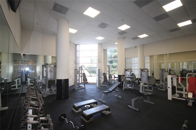 gym featuring a paneled ceiling and a high ceiling