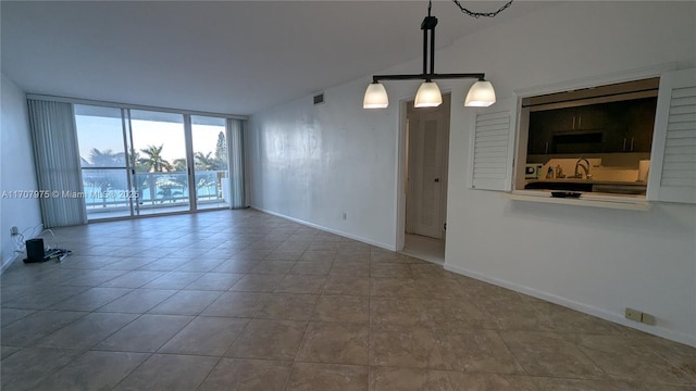 spare room with expansive windows and sink