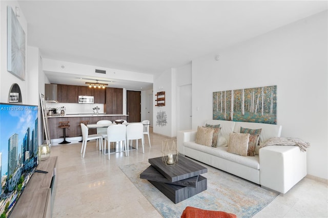 living room featuring an inviting chandelier and sink