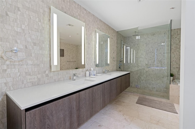 bathroom featuring vanity, a shower with door, tile walls, and tasteful backsplash