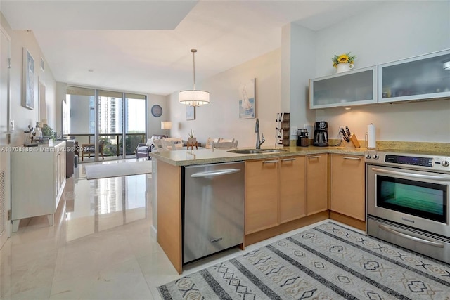 kitchen with pendant lighting, kitchen peninsula, sink, and stainless steel appliances