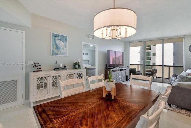 tiled dining space featuring a chandelier