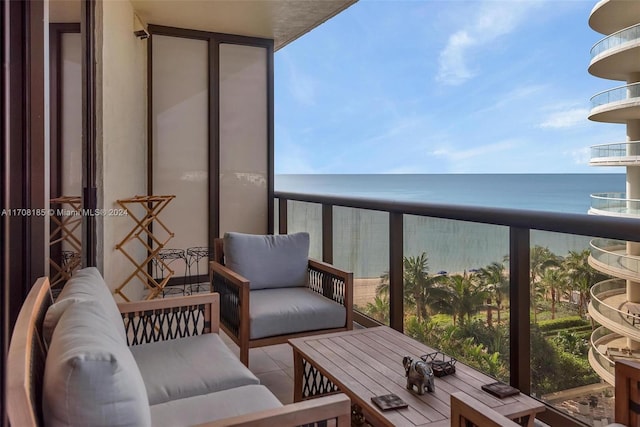 balcony featuring a water view and a view of the beach