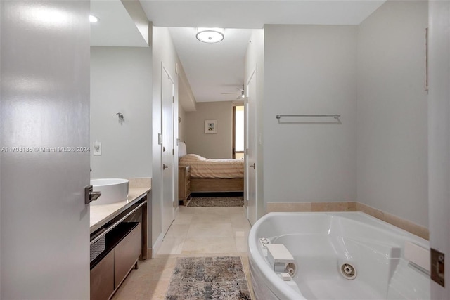 bathroom with tile patterned flooring, vanity, ceiling fan, and a bath