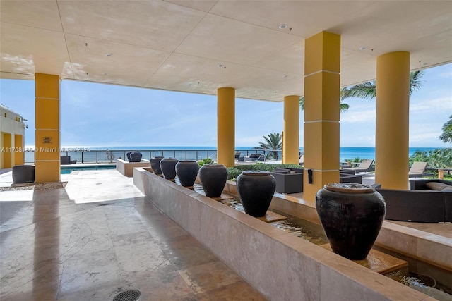 view of patio / terrace featuring a water view and a fenced in pool