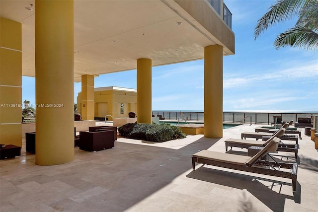 view of patio / terrace with area for grilling, a community pool, and a water view