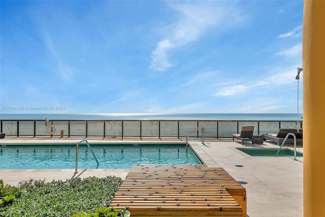 view of pool with outdoor lounge area, a patio area, and a water view