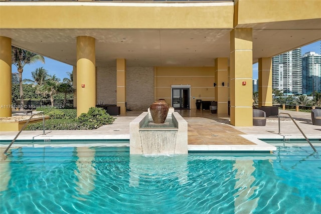 view of pool featuring pool water feature and a patio