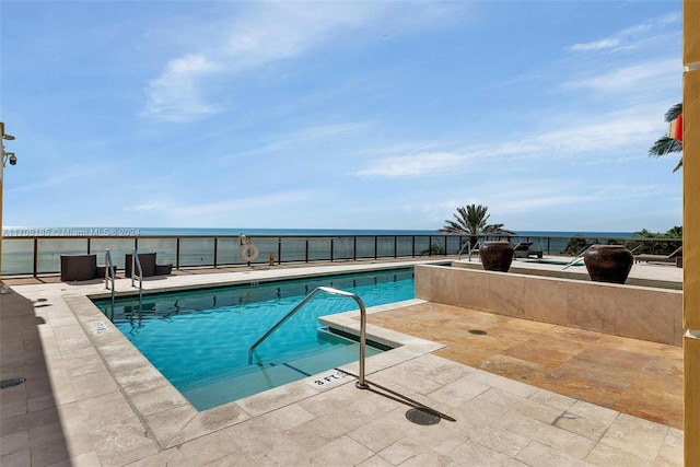 view of pool featuring a patio area and a water view