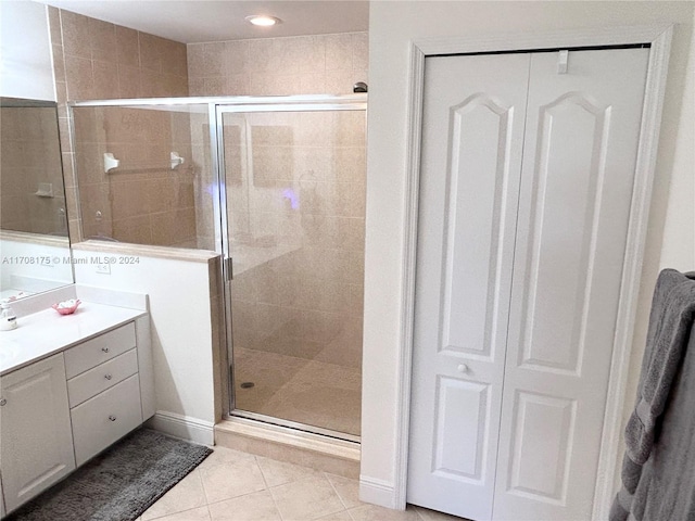 bathroom with tile patterned flooring, vanity, and a shower with door