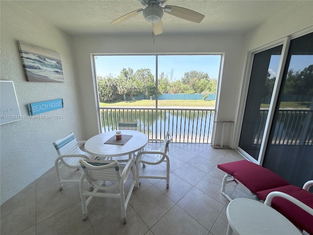 sunroom / solarium with a water view and ceiling fan