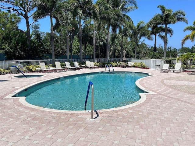 view of swimming pool featuring a patio area and a hot tub