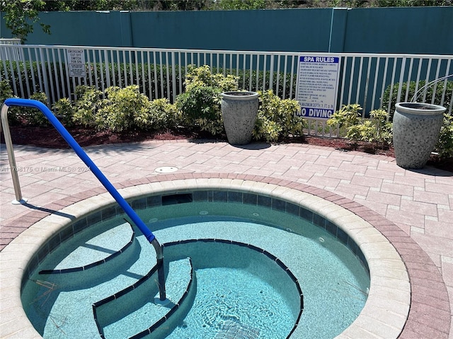 view of swimming pool featuring a hot tub