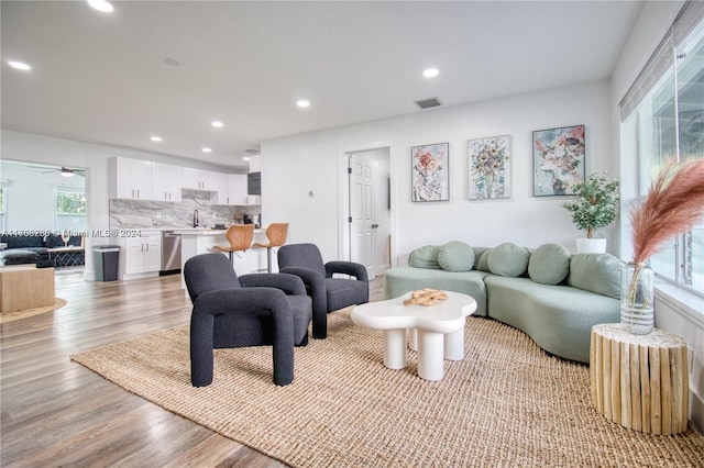 living room with light hardwood / wood-style flooring and sink