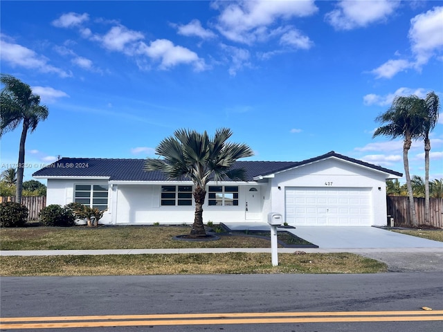 single story home featuring a front lawn and a garage