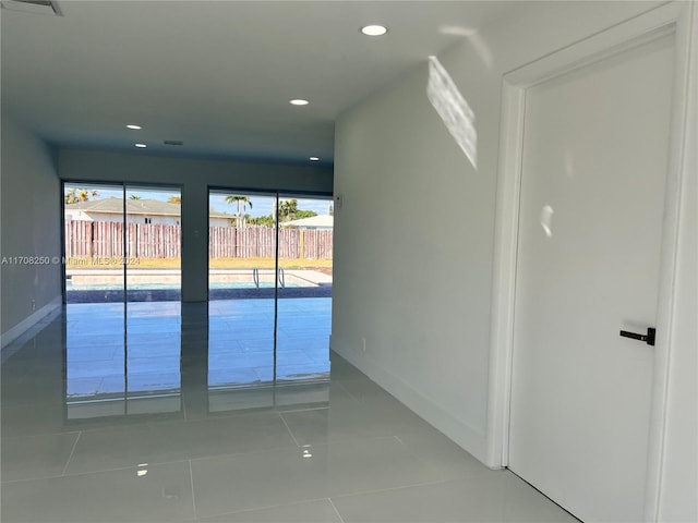 hall with tile patterned floors