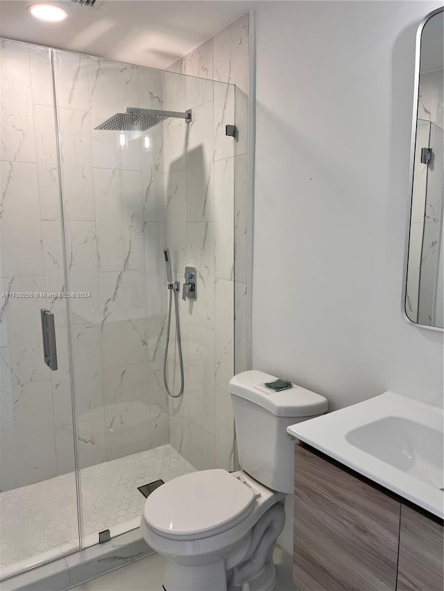 bathroom featuring a shower with door, vanity, and toilet