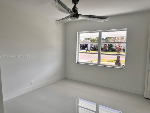 unfurnished room featuring ceiling fan and light tile patterned flooring