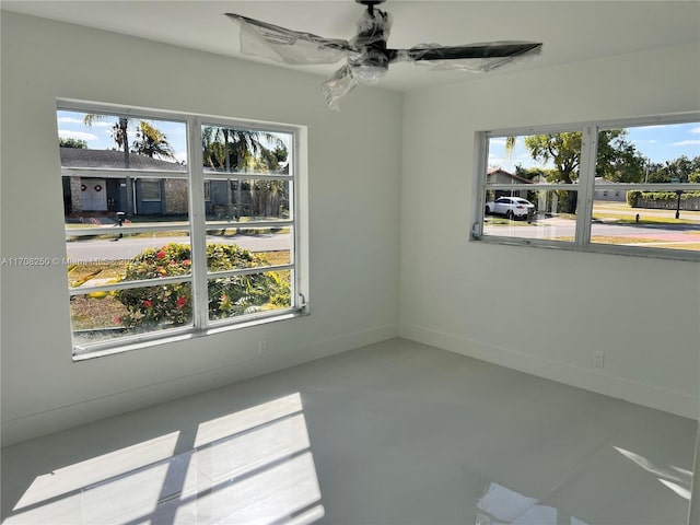 unfurnished room featuring plenty of natural light and ceiling fan