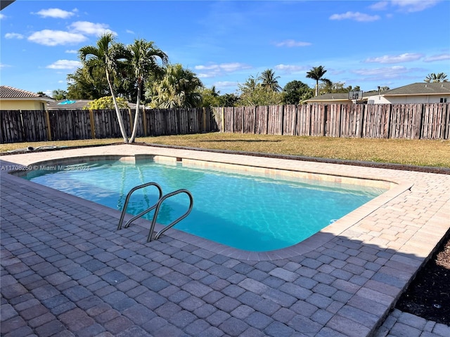 view of swimming pool featuring a lawn