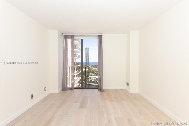 19667 Turnberry Way Unit 15A, Aventura, FL 33180 - empty room featuring wood finished floors, floor to ceiling windows, and a water view