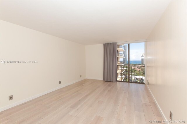 19667 Turnberry Way Unit 15A, Aventura, FL 33180 - empty room with expansive windows and light wood-style flooring