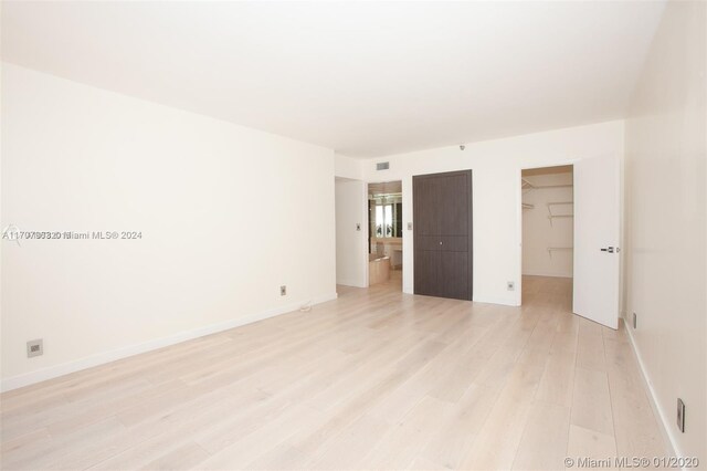 19667 Turnberry Way Unit 15A, Aventura, FL 33180 - unfurnished bedroom with light wood-type flooring, a spacious closet, and a closet